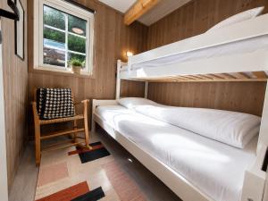 two bunk beds in a room with a chair and a window at Stunning 3-Bedroom Apartment at Feda Waterfront in Feda