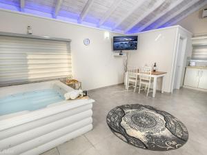 a large room with a hot tub and a table at בקתות לוטן דלתון - 4 בקתות עם ג'קוזי פרטי ו-2 בריכות משותפות in Shahar