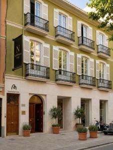 a yellow building with white windows and balconies at Nommadas Cotty - Only Adults in Denia