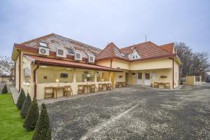a building with tables and chairs in a parking lot at Palmy Home Ecser in Ecser