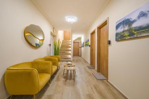 a living room with yellow furniture and a mirror at Palmy Home Ecser in Ecser