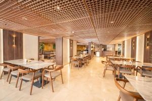 a dining room with tables and chairs in a restaurant at Maadi Hotel in Cairo