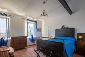 a bedroom with a bed with a blue blanket at B&B Anima Selvaggia Ranch in Castellero