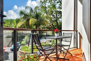 - Balcón con mesa y 2 sillas en Takapuna Beach Accommodation, en Auckland