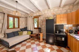 a living room with a couch and a kitchen at Botonis Houses - Modern Villas, Timeless Beauty in Vasilikos