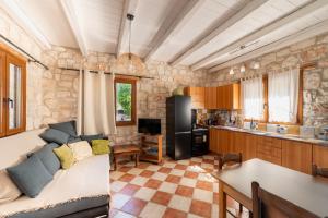 a living room with a couch and a kitchen at Botonis Houses - Modern Villas, Timeless Beauty in Vasilikos