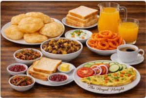 a wooden table with plates of food and drinks at The Royal Height in Nawāda