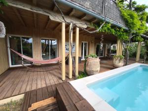 a porch with a hammock and a swimming pool at MAGNIFIQUE VILLA Terrasse, Jardin paysagé, Piscine, SPA et Sauna privé in Chauzon +11 photos