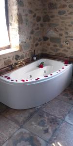 a white bath tub in a bathroom with roses on it at Mystras Panorama House in Mystras +25 photos