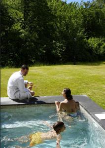 a man and a woman sitting in a swimming pool at Terra Homes in Kolašin