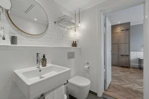 a white bathroom with a sink and a mirror at Hotel Kong Arthur in Copenhagen +50 photos