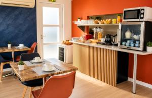 a kitchen with a counter and a table and chairs at Hôtel le Canetois in Canet-en-Roussillon