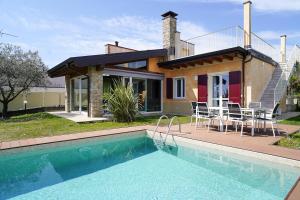 a house with a swimming pool in front of a house at Villa Ulivi Private Pool & Lake View in Montinelle