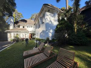 two wooden benches sitting in the yard of a house at SPA LIFESTYLE Centro de Bem Estar in Canela