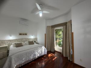 a white bedroom with a bed and a window at SPA LIFESTYLE Centro de Bem Estar in Canela
