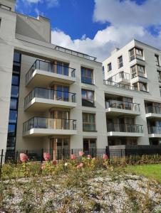 an apartment building with flowers in front of it at Nowoczesny Apartament 400 M Od Plaży Prywatny Ogródek Ełk in Ełk