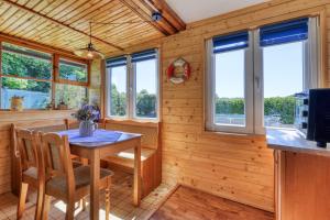 a dining room with a table and some windows at Modrobílá chatka u rybníka in Holoubkov