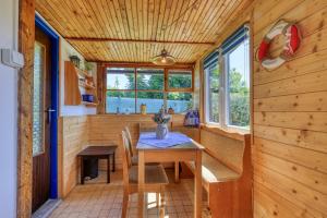 a dining room with a table in a tiny house at Modrobílá chatka u rybníka in Holoubkov