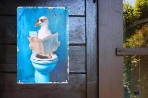 a picture of a duck sitting on a toilet at Modrobílá chatka u rybníka in Holoubkov