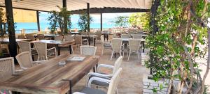 a restaurant with tables and chairs and the ocean at Apartment SM in Herceg-Novi