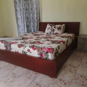a bedroom with a bed with flowers on it at Roof View Macaneta in Praia de Macaneta
