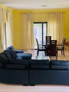 a living room with a couch and a table and chairs at Roof View Macaneta in Praia de Macaneta