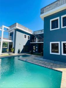 a house with a swimming pool in front of a house at Roof View Macaneta in Praia de Macaneta