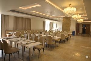 a conference room with tables and chairs and a chandelier at Sawarthia Sewa Sadan, Ayodhya in Ayodhya