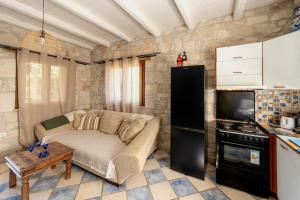 a living room with a couch and a stove at Botonis Houses - Modern Villas, Timeless Beauty in Vasilikos +35 photos