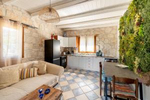 a living room with a couch and a kitchen at Botonis Houses - Modern Villas, Timeless Beauty in Vasilikos