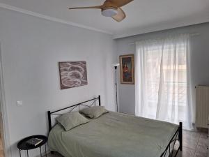 a bedroom with a bed and a ceiling fan at Elia rooms in Neoi Epivates