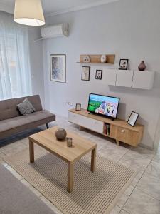 a living room with a couch and a tv at Elia rooms in Neoi Epivates