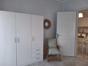a room with a white cabinet and a chair at Elia rooms in Neoi Epivates +3 photos