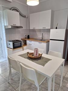 a kitchen with a white table and white cabinets at Elia rooms in Neoi Epivates