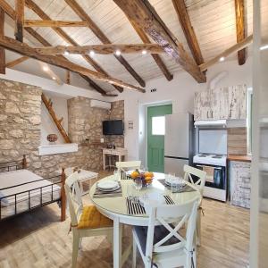 a kitchen and dining room with a table and chairs at Alekos Cozy Stone 2BR Home Karya Center in Lefkada