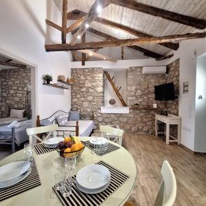 a dining room with a table with a bowl of fruit on it at Alekos Cozy Stone 2BR Home Karya Center in Lefkada