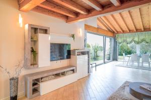 a large living room with a large tv and a large window at Villa Ulivi Private Pool & Lake View in Montinelle