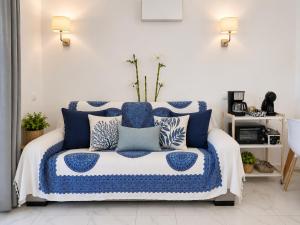 a bedroom with a blue and white bed with pillows at Roby&Vito Vista Taurito in Taurito