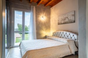 a bedroom with a bed and a large window at Villa Ulivi Private Pool & Lake View in Montinelle +28 photos