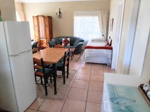 a living room with a table and a refrigerator at Alpha Self-Catering in Sutherland