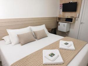 a bedroom with a large bed with two white pillows at Hotel Pampa in Nova Santa Medianeira