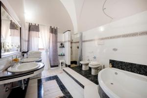 a bathroom with two sinks and a tub and a toilet at Masseria Lamapecora in Faccia di Trippa +94 photos