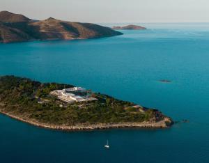 an island in the ocean with a building on it at Minos Palace Resort - Adults Only in Agios Nikolaos