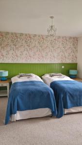 two beds in a room with green and pink wallpaper at Luachra Lodge in Killarney +50 photos
