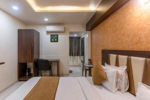 a hotel room with a bed and a desk at Hotel Ashish in Ahmedabad +54 photos