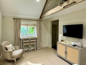 a living room with a flat screen tv and a desk at Black Drove Farm in Twenty