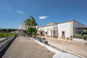 an empty street in front of a white building at Masseria Lamapecora in Faccia di Trippa