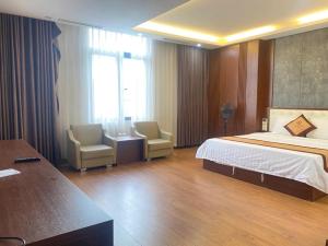 a hotel room with a bed and two chairs at Tv Hotel in Cao Bằng +1 photo