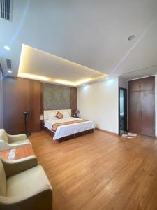 a bedroom with a bed and a couch in a room at Tv Hotel in Cao Bằng