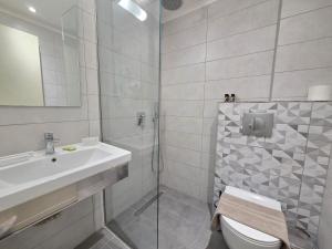 a bathroom with a sink and a toilet and a shower at Coco's Corfu Apartments in Ipsos +38 photos